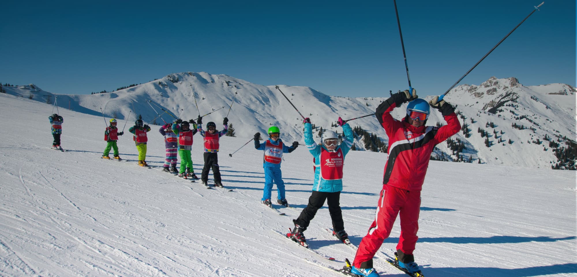 Skilehrerin mit Kindern auf der Kinderwiese